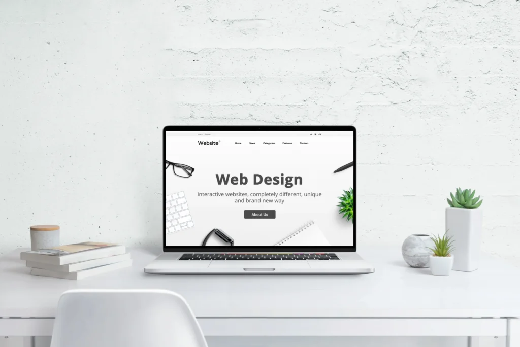 デスクの上にあるPC画面に"Web design”の文字が表示されている